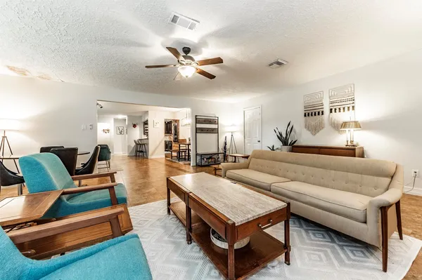 a living room with furniture and wooden floor