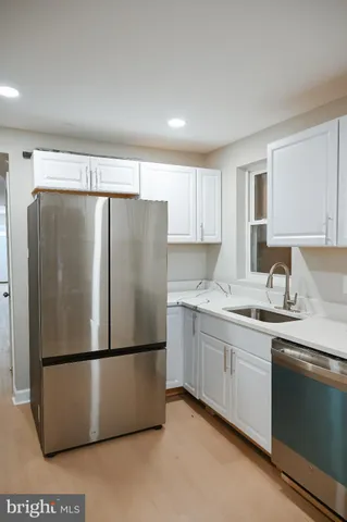 a kitchen with stainless steel appliances granite countertop grey cabinets a stove a sink and dishwasher