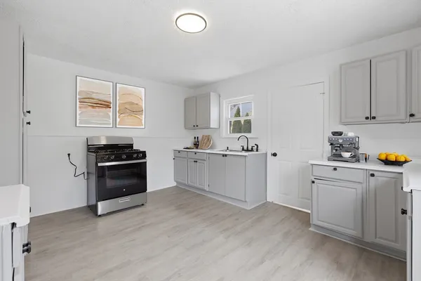 a kitchen with granite countertop a sink cabinets and stainless steel appliances