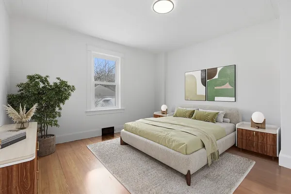 a bedroom with a large bed and a potted plant