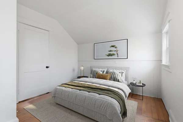 a bedroom with a bed and painting on the wall