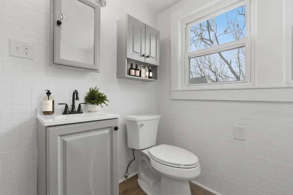 a bathroom with a toilet a sink and a window