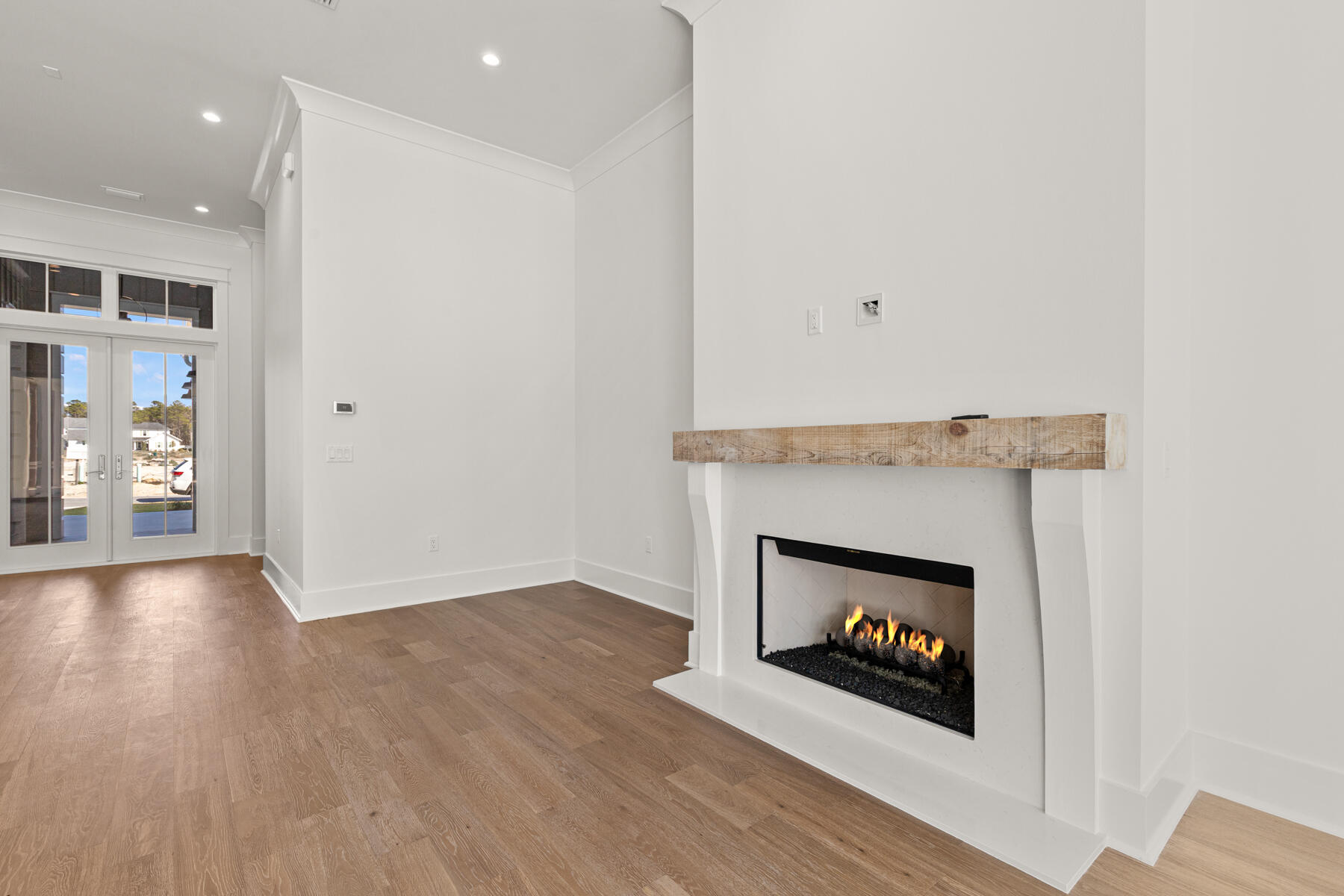 74 Pollard Cove West, Unit LOT 41 Watersound, FL 32461 - Photo 29 of 62 an empty room with wooden floor fireplace and windows