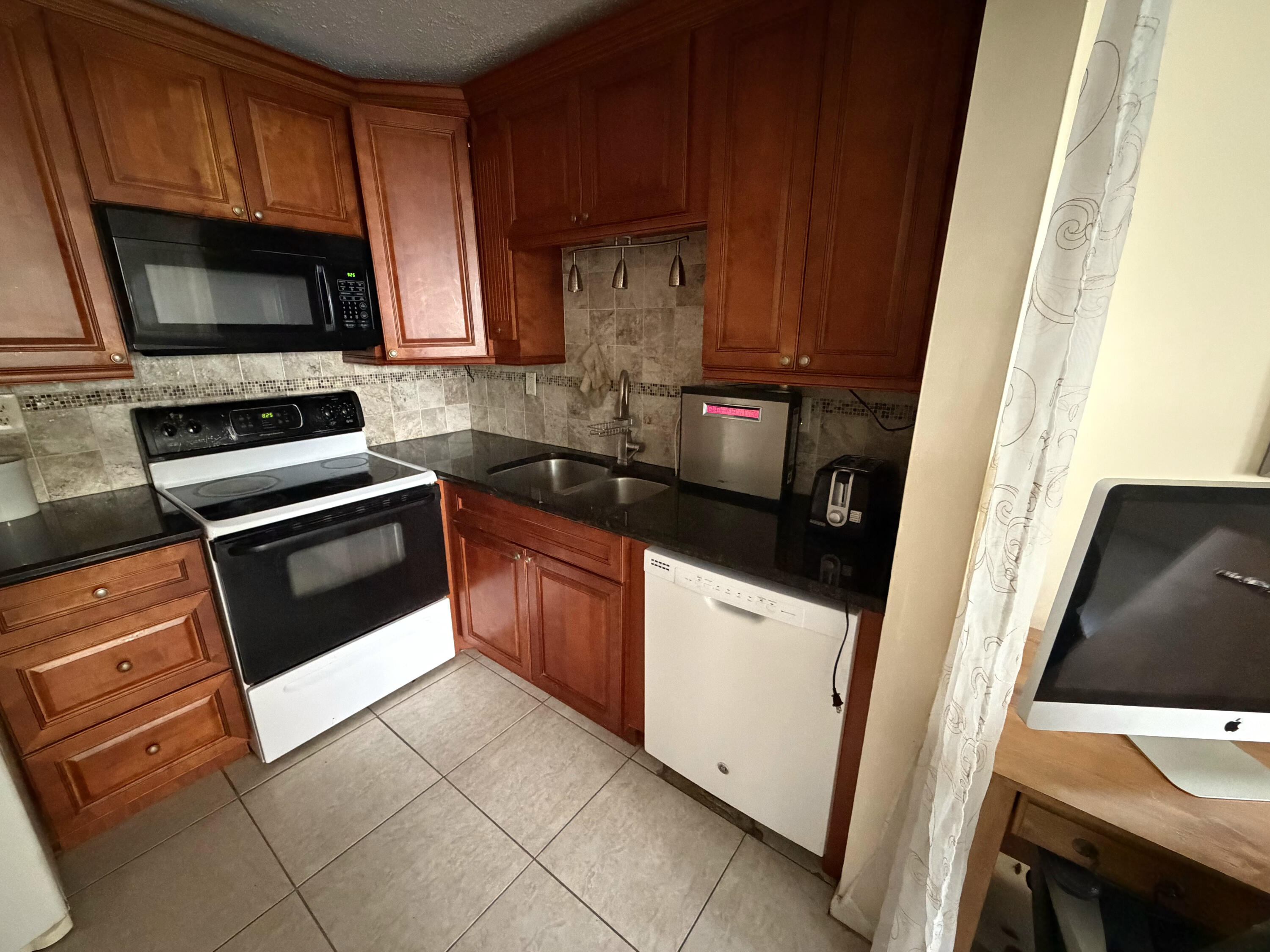7 Flanders A Delray Beach, FL 33484 - Photo 3 of 4 a kitchen with granite countertop a refrigerator stove and microwave
