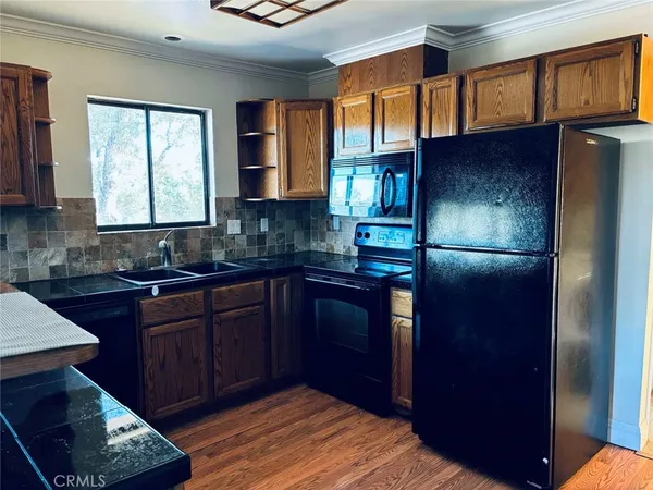 a kitchen with granite countertop stainless steel appliances a refrigerator and a sink