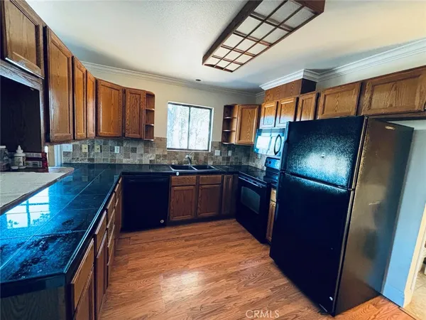 a view of an empty room with wooden floor and closet