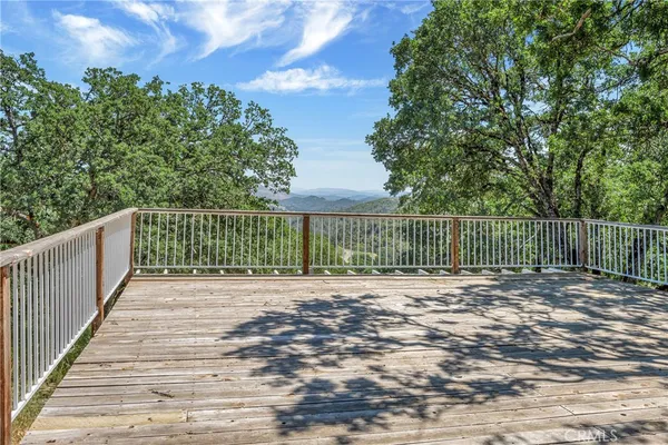 a view of a balcony with wooden floor and fence