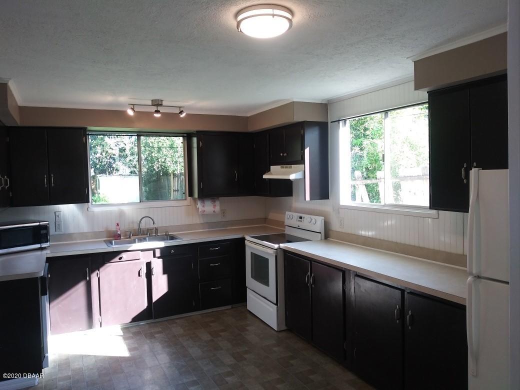939 West Granada Boulevard Ormond Beach, FL 32174 - Photo 2 of 14 a kitchen with a sink and a stove