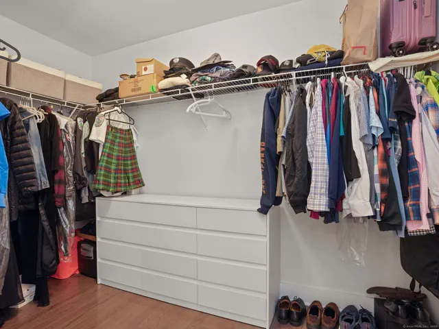 a view of walk in closet with clothes and shoes