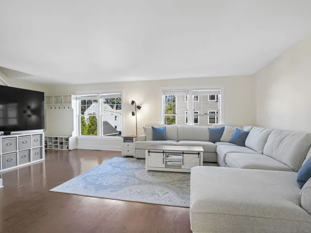 a living room with furniture wooden floor and a flat screen tv