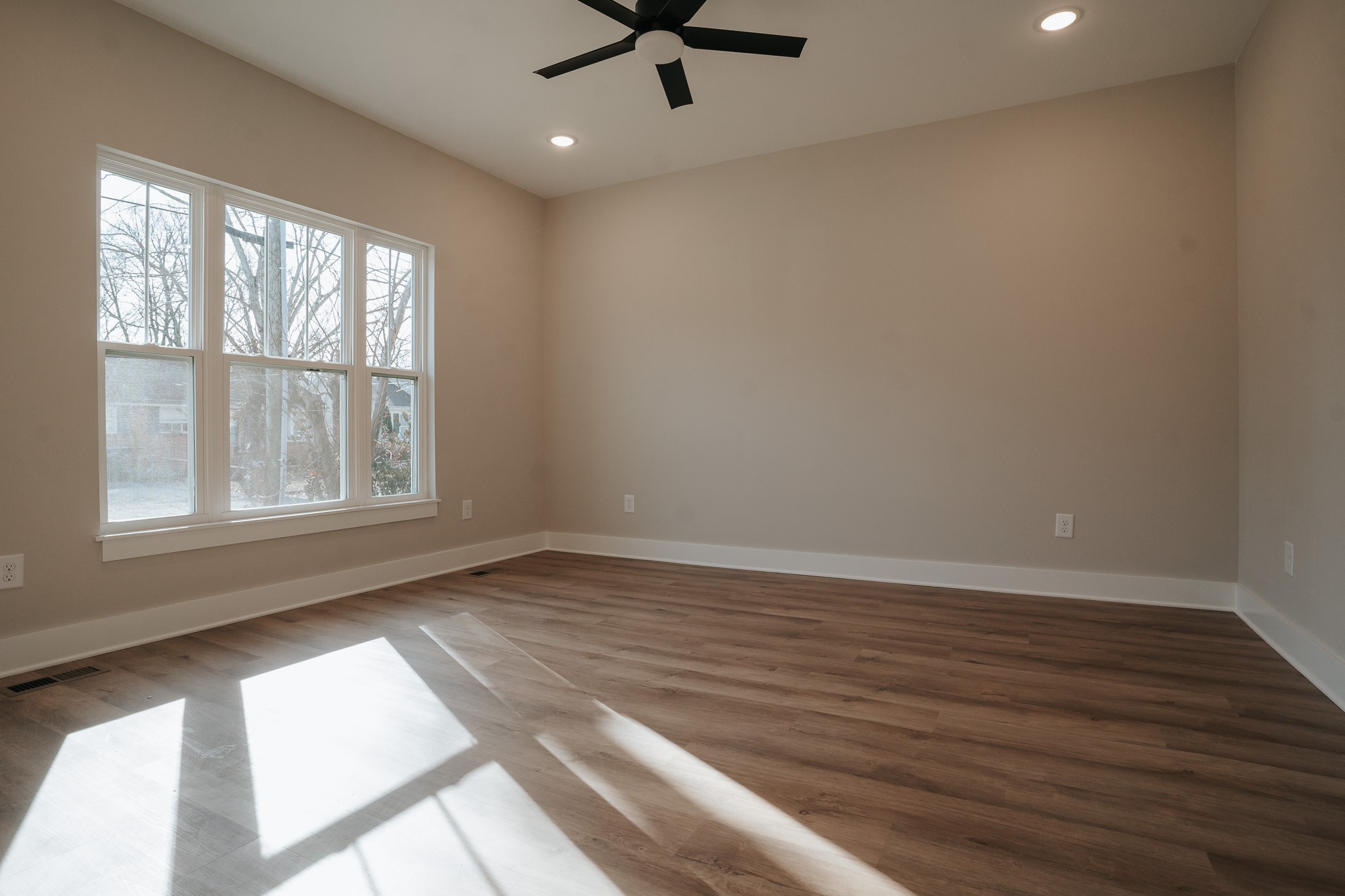 795 19th Avenue West Springfield, TN 37172 - Photo 3 of 26 an empty room with wooden floor fan and windows