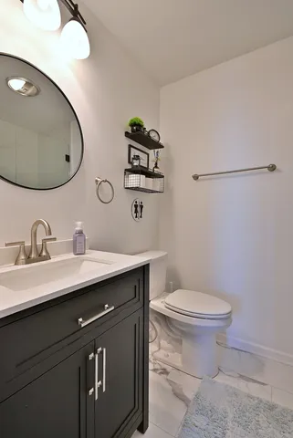 a bathroom with a toilet a sink and mirror