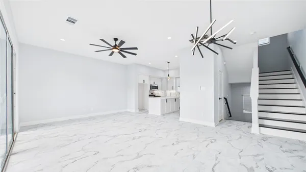 a view of a room with a ceiling fan and entryway