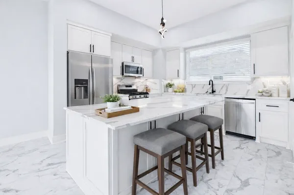 a kitchen with a sink a counter space appliances and cabinets