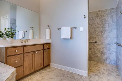 a bathroom with a sink a potted plant and mirror