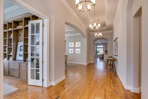a view of a hallway with wooden floor and a dining room