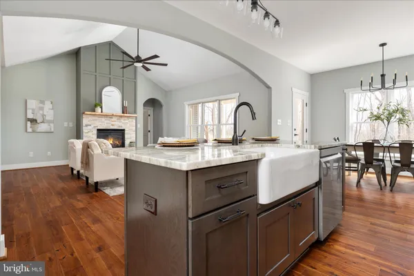 a bathroom with a granite countertop toilet a sink and a mirror