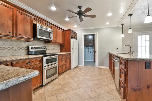 a kitchen with stainless steel appliances granite countertop a refrigerator a stove top oven a sink and dishwasher