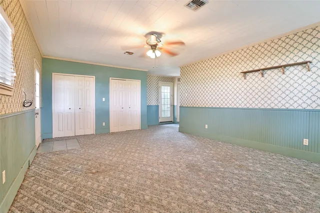 an empty room with a ceiling fan and a window