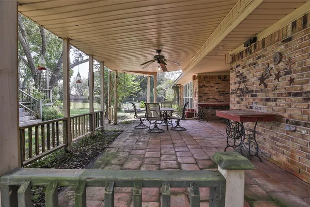 a view of a patio with table and chairs potted plants with wooden floor and floor to ceiling window
