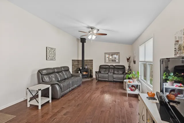 a living room with furniture ceiling fan and a wooden floor