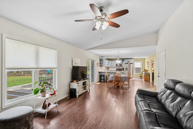 a living room with furniture and a flat screen tv with wooden floor
