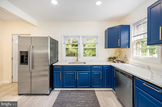 a kitchen with stainless steel appliances a stove a sink a window and cabinets