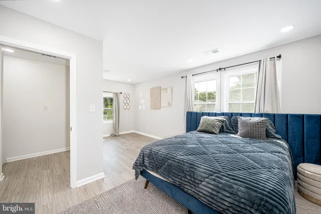 a bathroom with a granite countertop sink a toilet a mirror a bathtub and shower