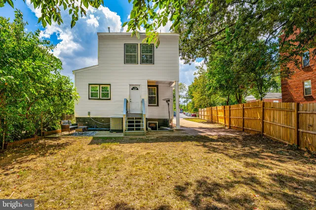 a view of a swimming pool with a lawn chairs and a small yard