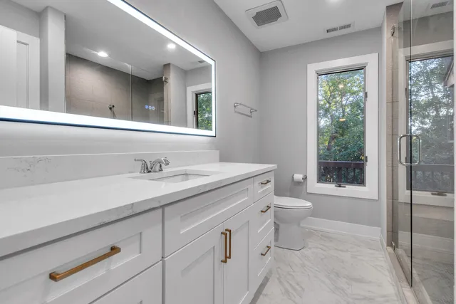 a bathroom with a toilet a sink and a large mirror