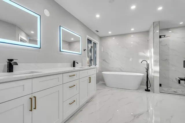 a bathroom with a double vanity sink a bathtub and shower