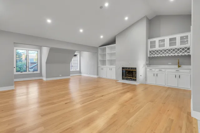 a view of an empty room with a window and fireplace