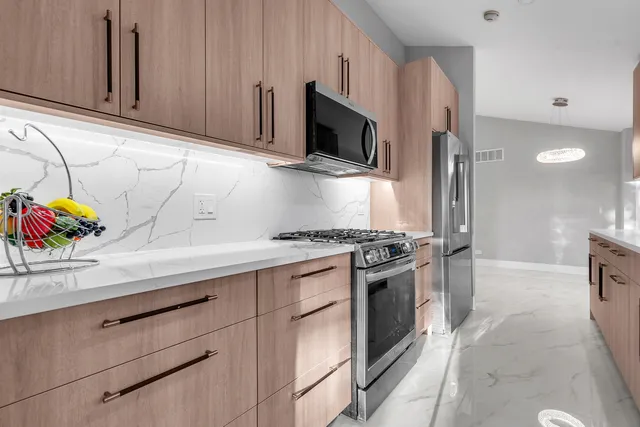 a kitchen with stainless steel appliances granite countertop a sink and a stove