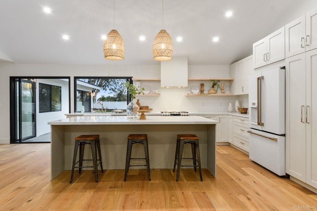 13705 Mango Drive Del Mar, CA 92014 - Photo 9 of 35 a kitchen with stainless steel appliances granite countertop a sink a stove a refrigerator and wooden floor