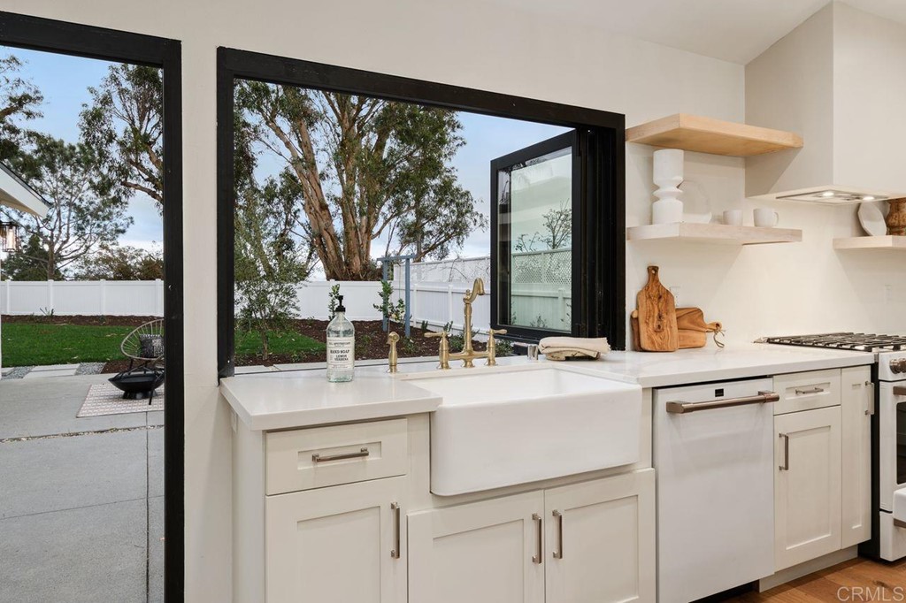 13705 Mango Drive Del Mar, CA 92014 - Photo 10 of 35 a kitchen with white cabinets and white appliances