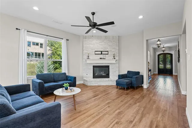 a living room with furniture a fireplace and a large window