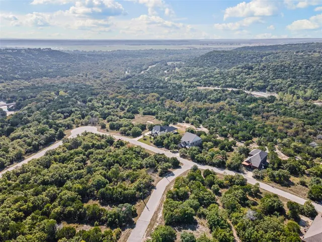 an aerial view of residential houses with outdoor space and trees