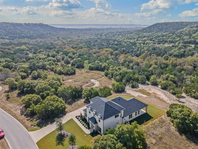 an aerial view of a house with a mountain