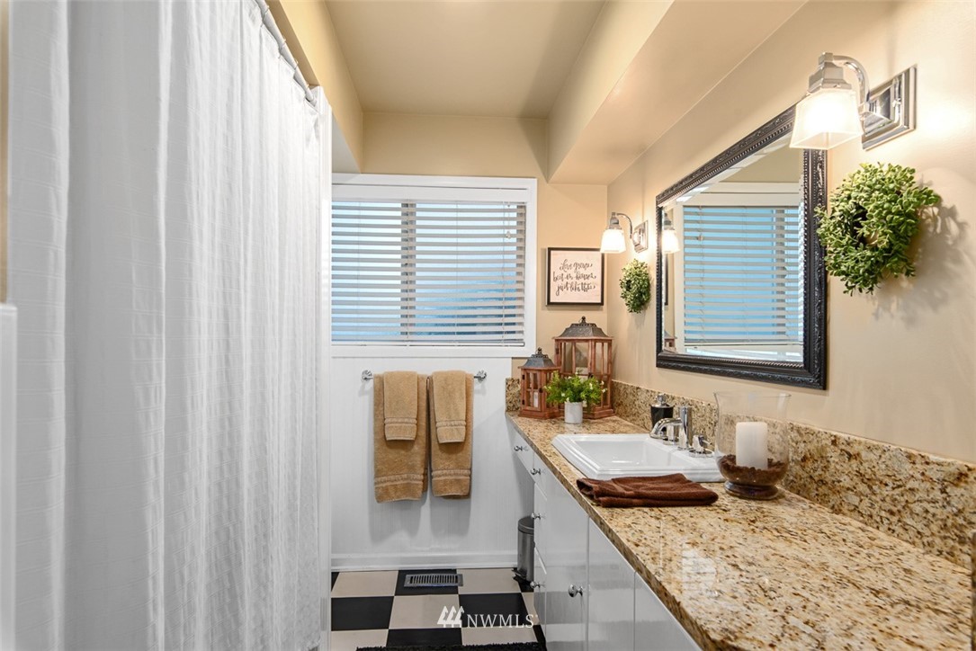5495 Sand Road Bellingham, WA 98226 - Photo 23 of 40 a bathroom with a granite countertop sink and a mirror