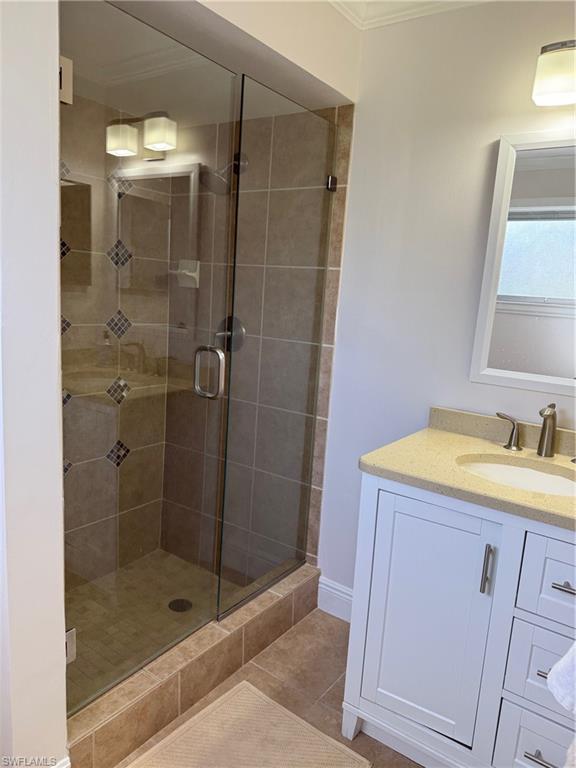 1927 Crayton Road Naples, FL 34102 - Photo 12 of 21 Full bathroom with a shower stall, vanity, ornamental molding, and tile patterned floors