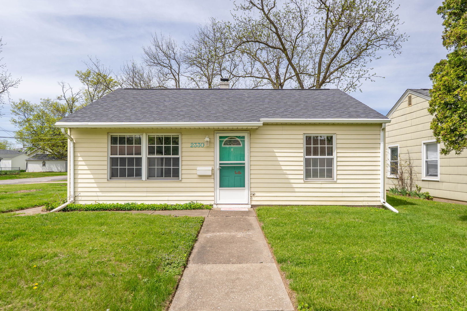 a front view of a house with a yard and garden