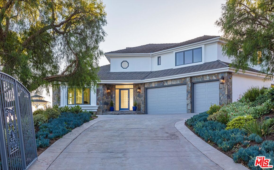 Carbon Mesa Road Malibu, CA 90265 - Photo 3 of 42 a front view of a house with a yard and garage