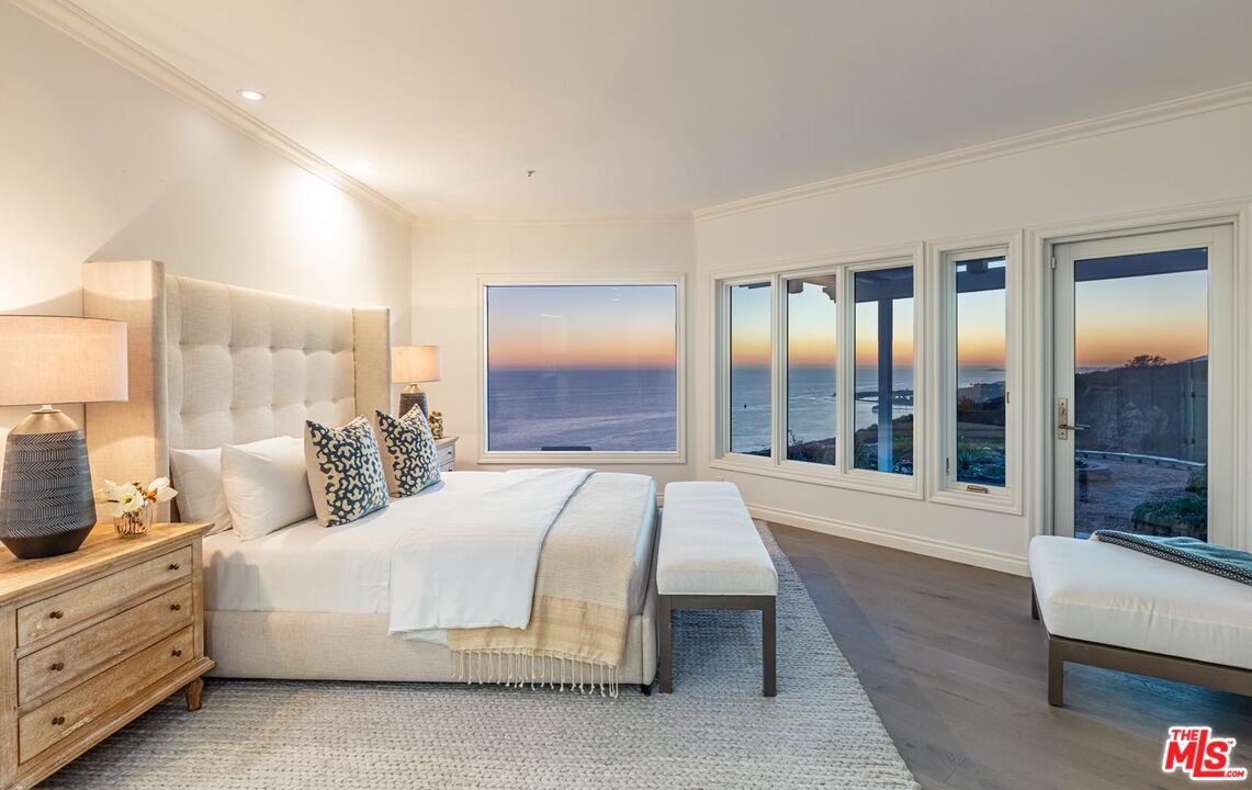 Carbon Mesa Road Malibu, CA 90265 - Photo 37 of 42 a spacious bedroom with a large bed and a large window