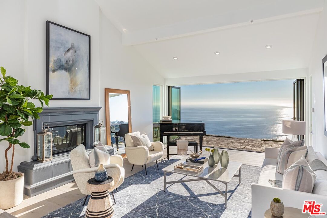Carbon Mesa Road Malibu, CA 90265 - Photo 5 of 42 a living room with fireplace furniture and a potted plant