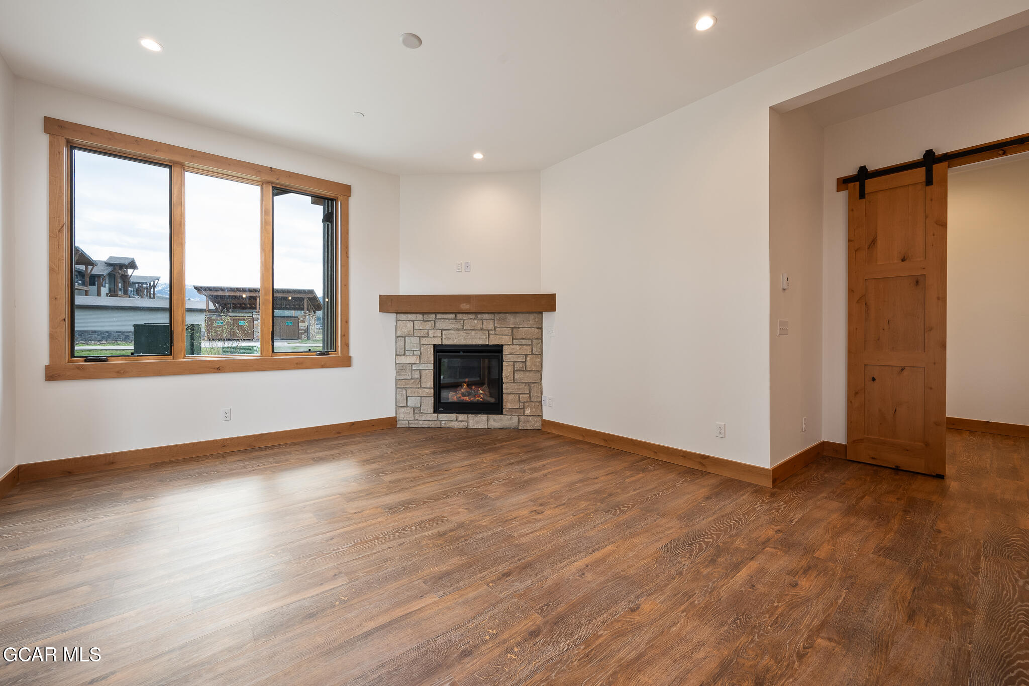 96 Meadow Trail, Unit G101 Fraser, CO 80442 - Photo 3 of 19 an empty room with wooden floor fireplace and windows