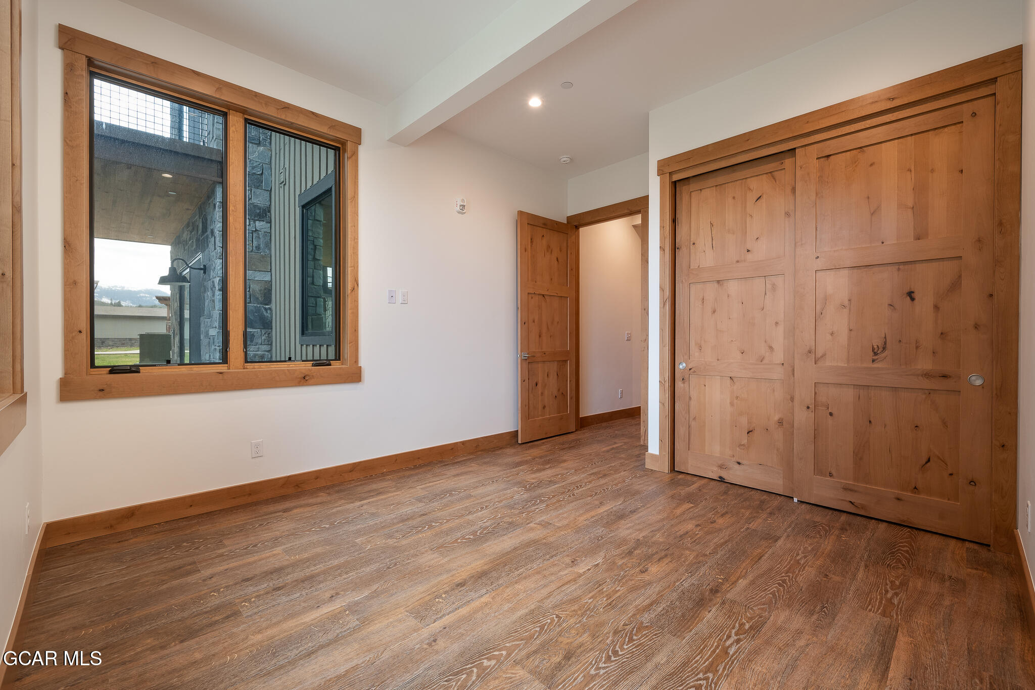 96 Meadow Trail, Unit G101 Fraser, CO 80442 - Photo 7 of 19 an empty room with wooden floor and windows