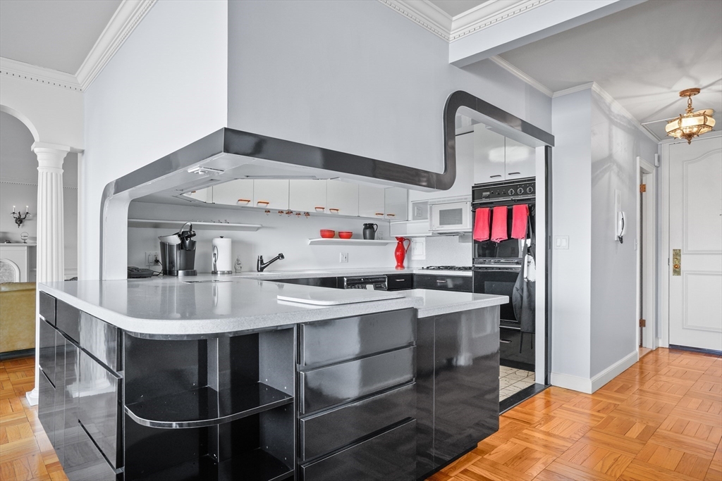 180 Beacon Street, Unit 14FG Boston, MA 02116 - Photo 14 of 40 a kitchen with kitchen island a stove a sink dishwasher and cabinets with wooden floor