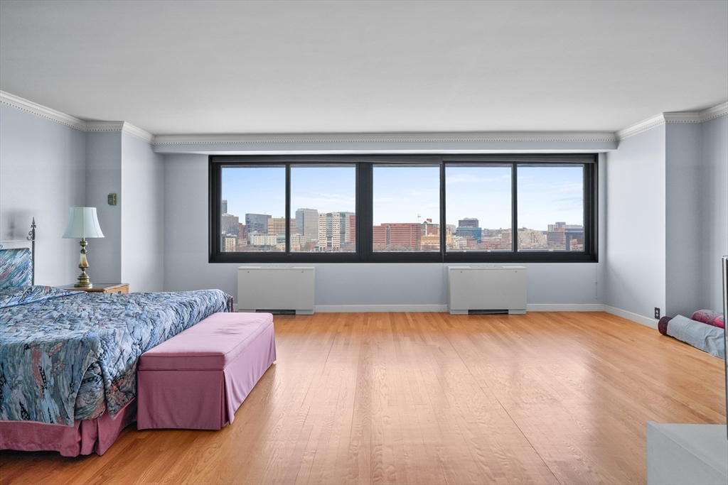 180 Beacon Street, Unit 14FG Boston, MA 02116 - Photo 18 of 40 a living room with a large bed and a large window
