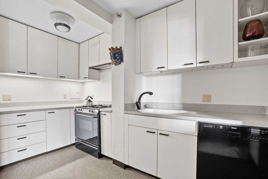 180 Beacon Street, Unit 14FG Boston, MA 02116 - Photo 27 of 40 a kitchen with cabinets appliances a sink and a counter top space
