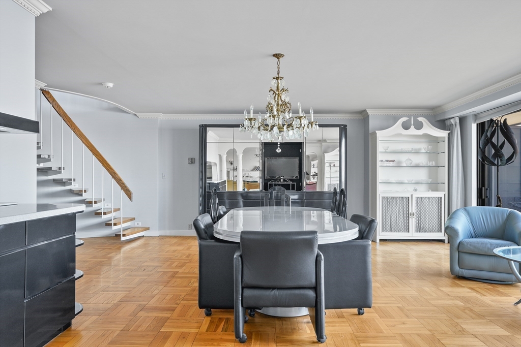 180 Beacon Street, Unit 14FG Boston, MA 02116 - Photo 10 of 40 a living room with furniture a chandelier and a dining table